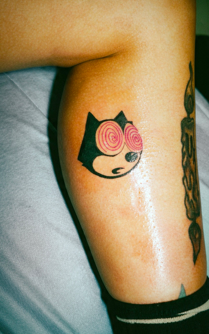 tattoo of Felix the cat cartoon with hypnotized eyes on a lower leg.