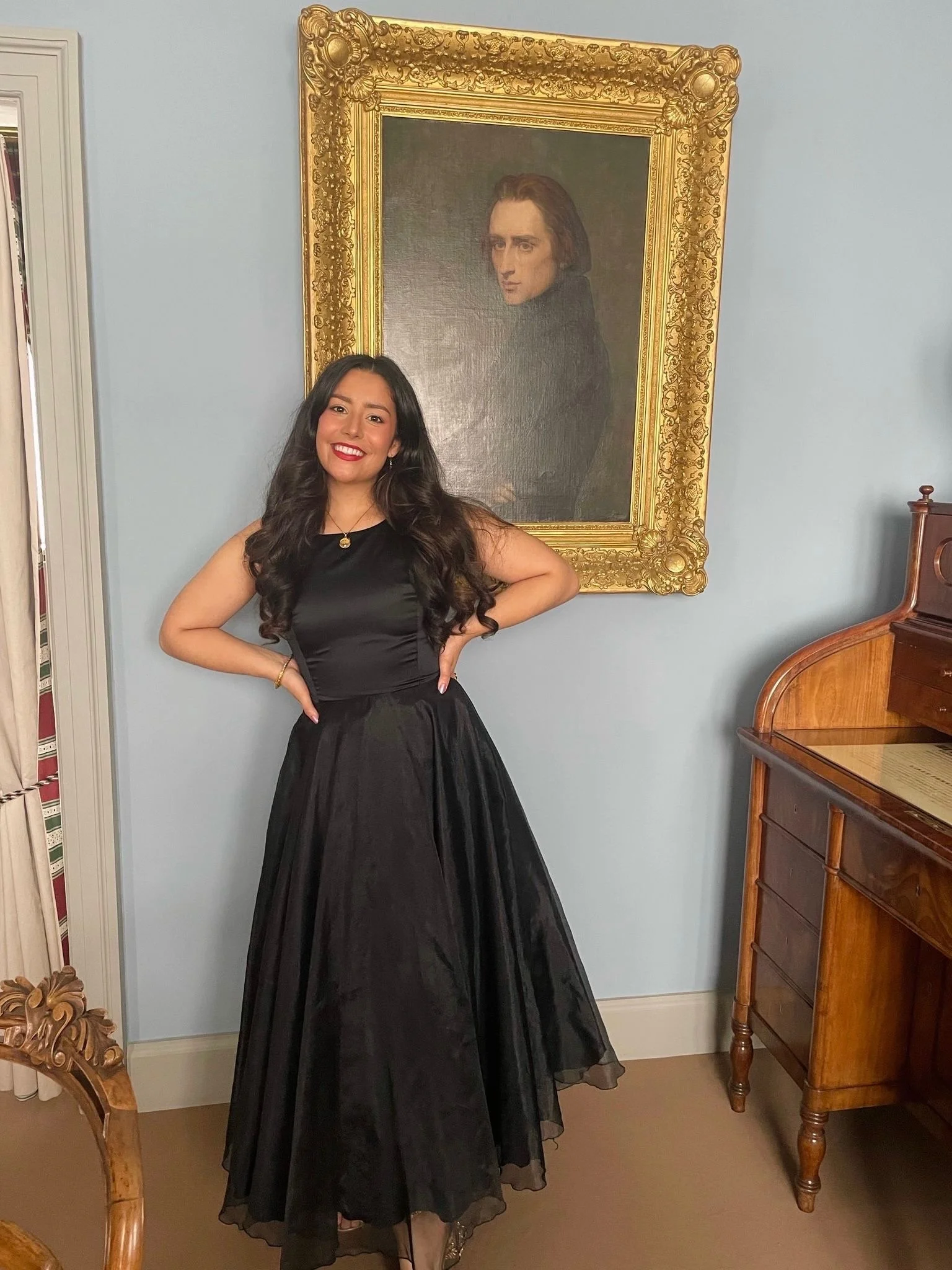 Uma Singh in Weimar, Germany beneath a photo of Franz Liszt
