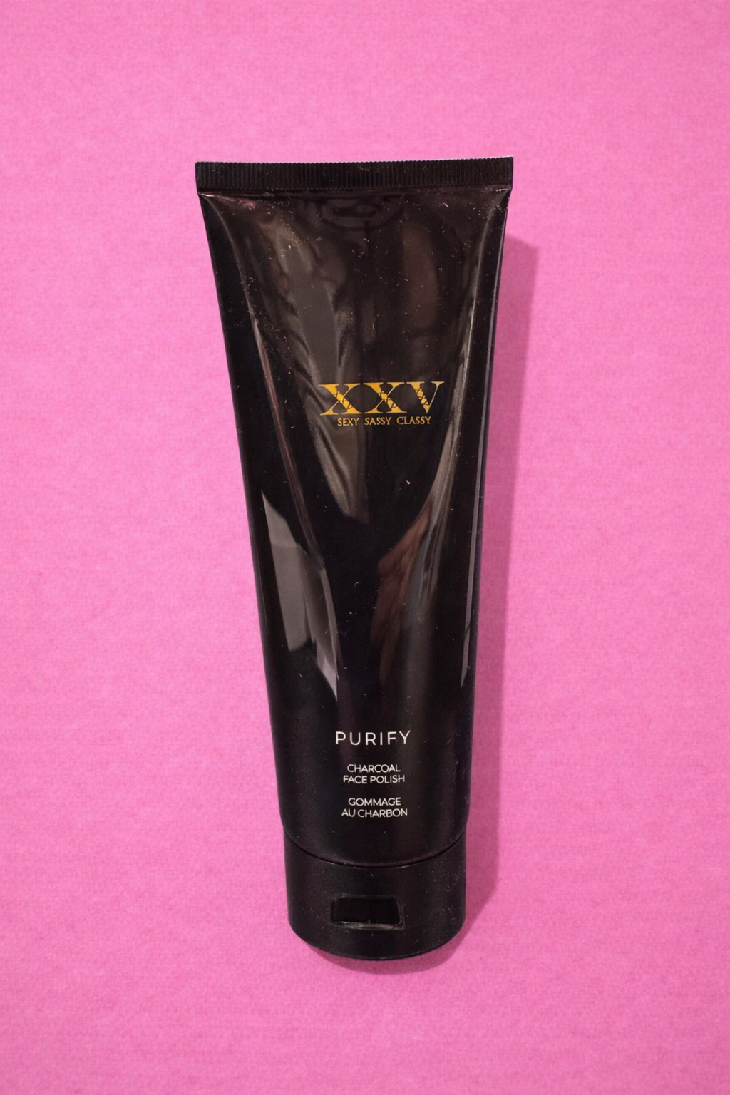 Glossy charcoal face polish on pink.png