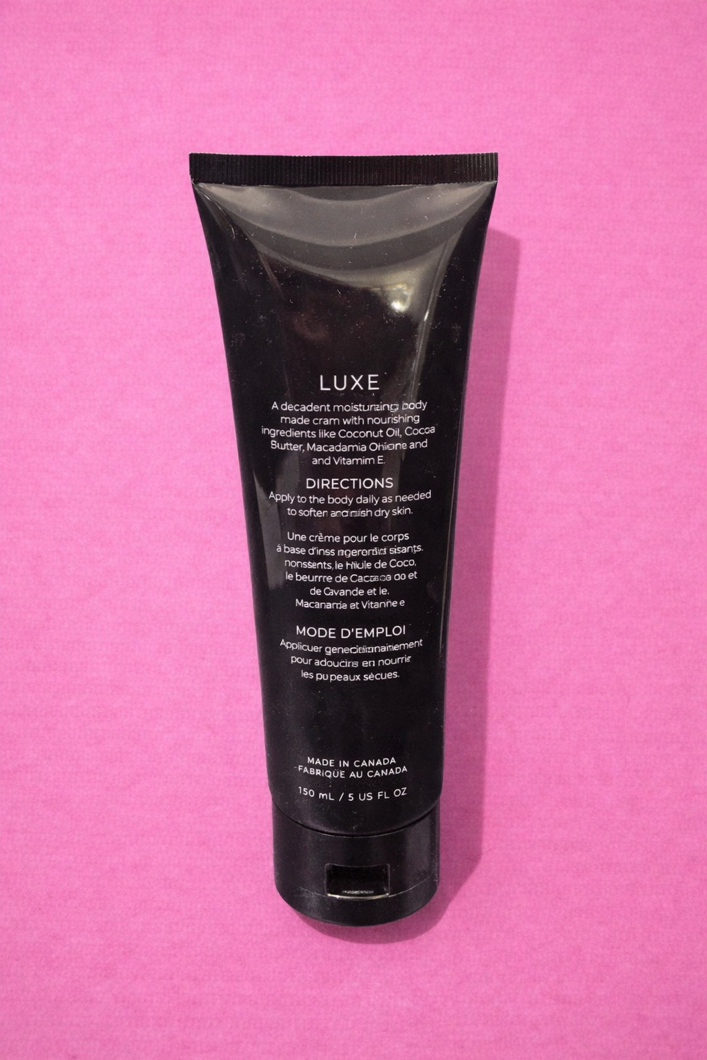 Luxe body cream on pink backdrop.png