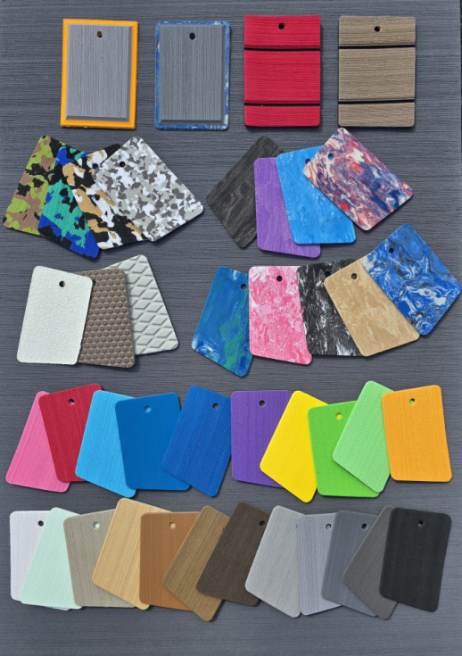 Collection of various color and texture sample tiles and wood veneer samples arranged on a gray surface.
