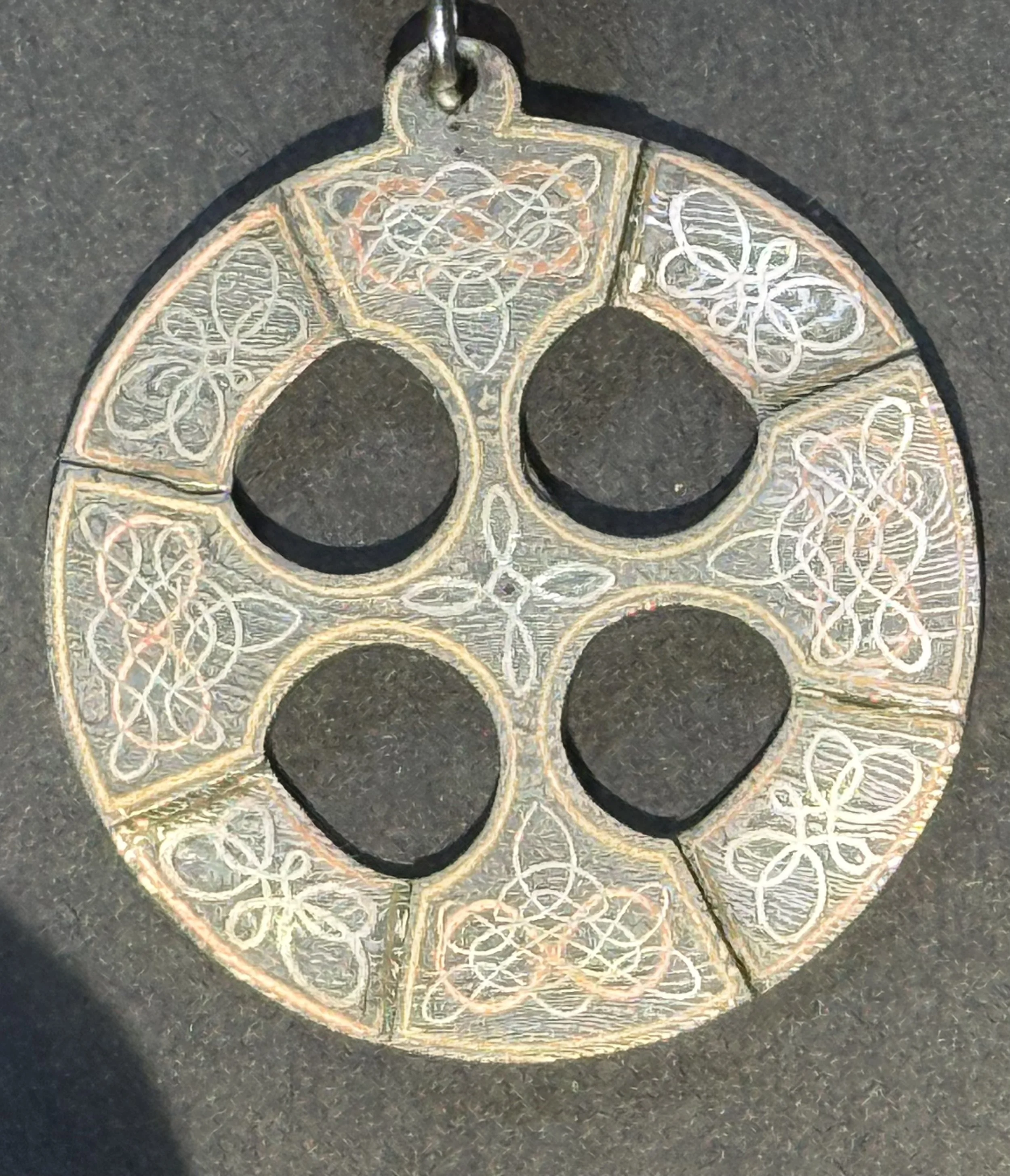 close-up of hand-engraved Celtic cross on Damascus stainless steel with metal inlay Celtic knots.