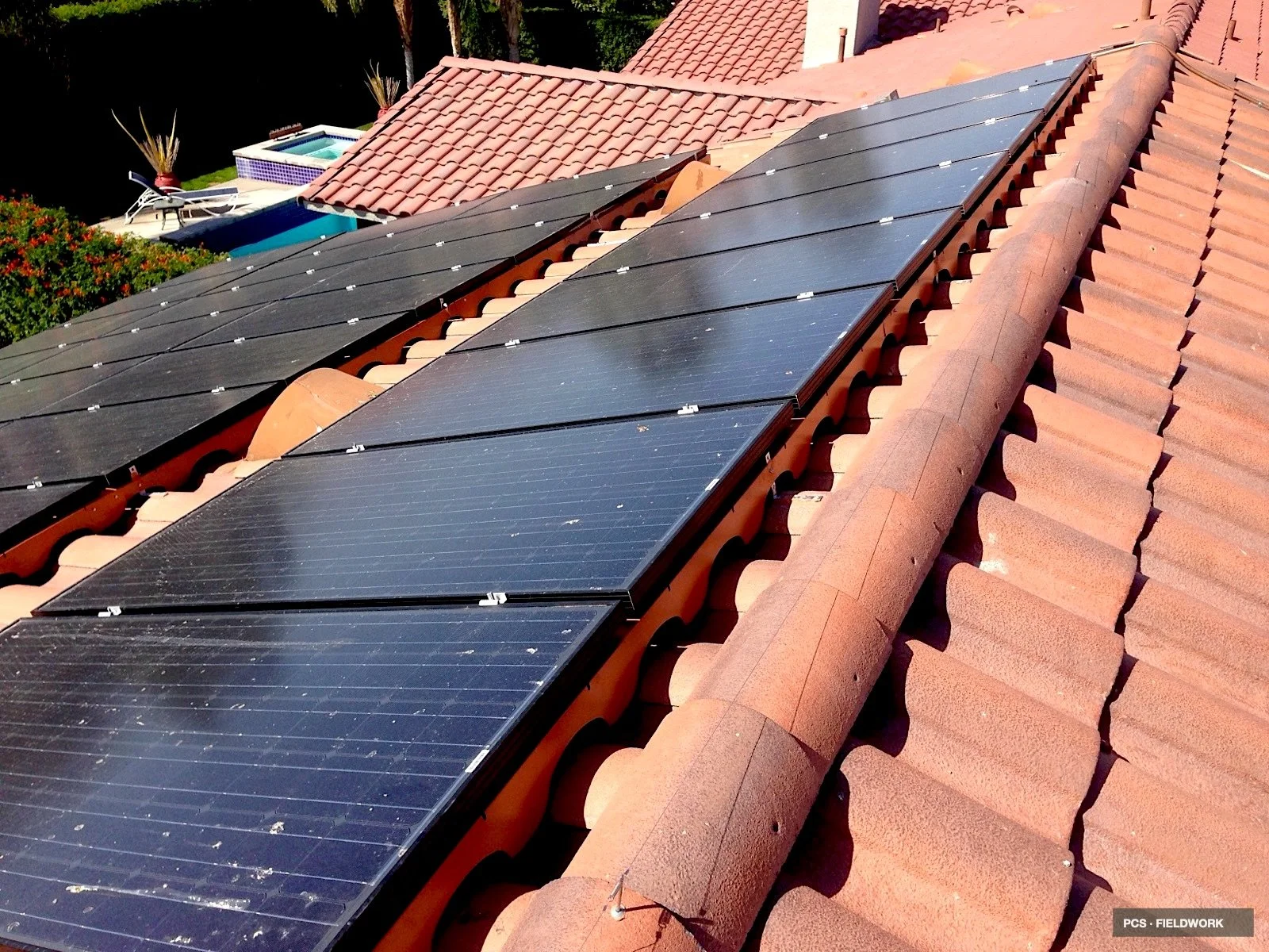 Solar panels installed on a red tiled roof of a house.