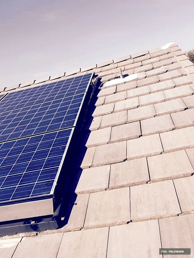 Close-up view of a solar panel installed on a tiled roof.
