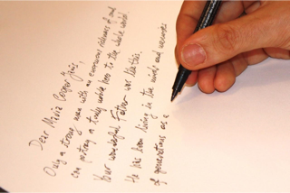 Tomasz inscribing poster (close-up).png