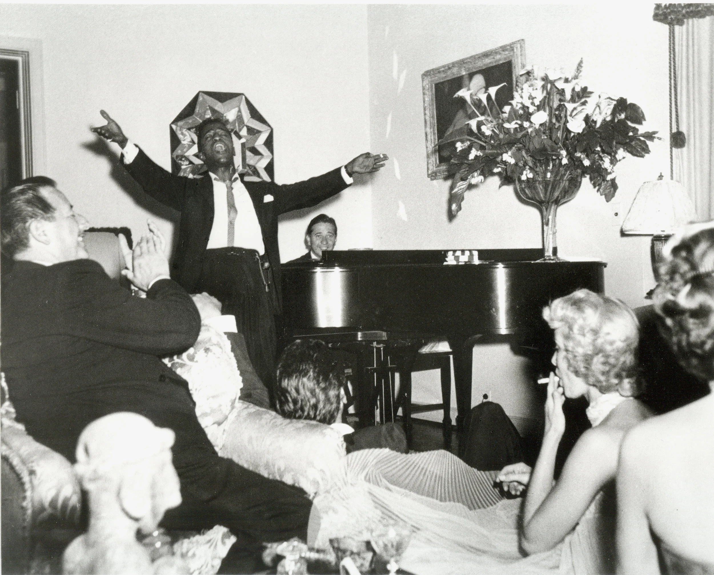 A party at home. We all had the great pleasure of hearing Sammy Davis Jr. serenade us after dinner. He had recently moved to Hollywood and in this photo joined in an after dinner jam session that often happened around our piano —making music with som