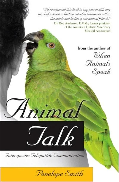 Book cover titled 'Animal Talk: Interspecies Telepathic Communication' by Penelope Smith, featuring a large green parrot with a yellow beak, perched next to a person with dark curly hair, both highlights visible.