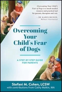 Cover of a book titled "Overcoming Your Child's Fear of Dogs: A Step-by-Step Guide for Parents" by Stefani M. Cohen, with contributions from Cathy Malkin. The cover features a young boy sitting on the grass with a dog, and another child with her dog in the background.