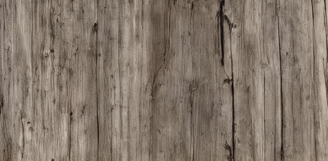 Close-up of a weathered wooden surface with visible grain and cracks.