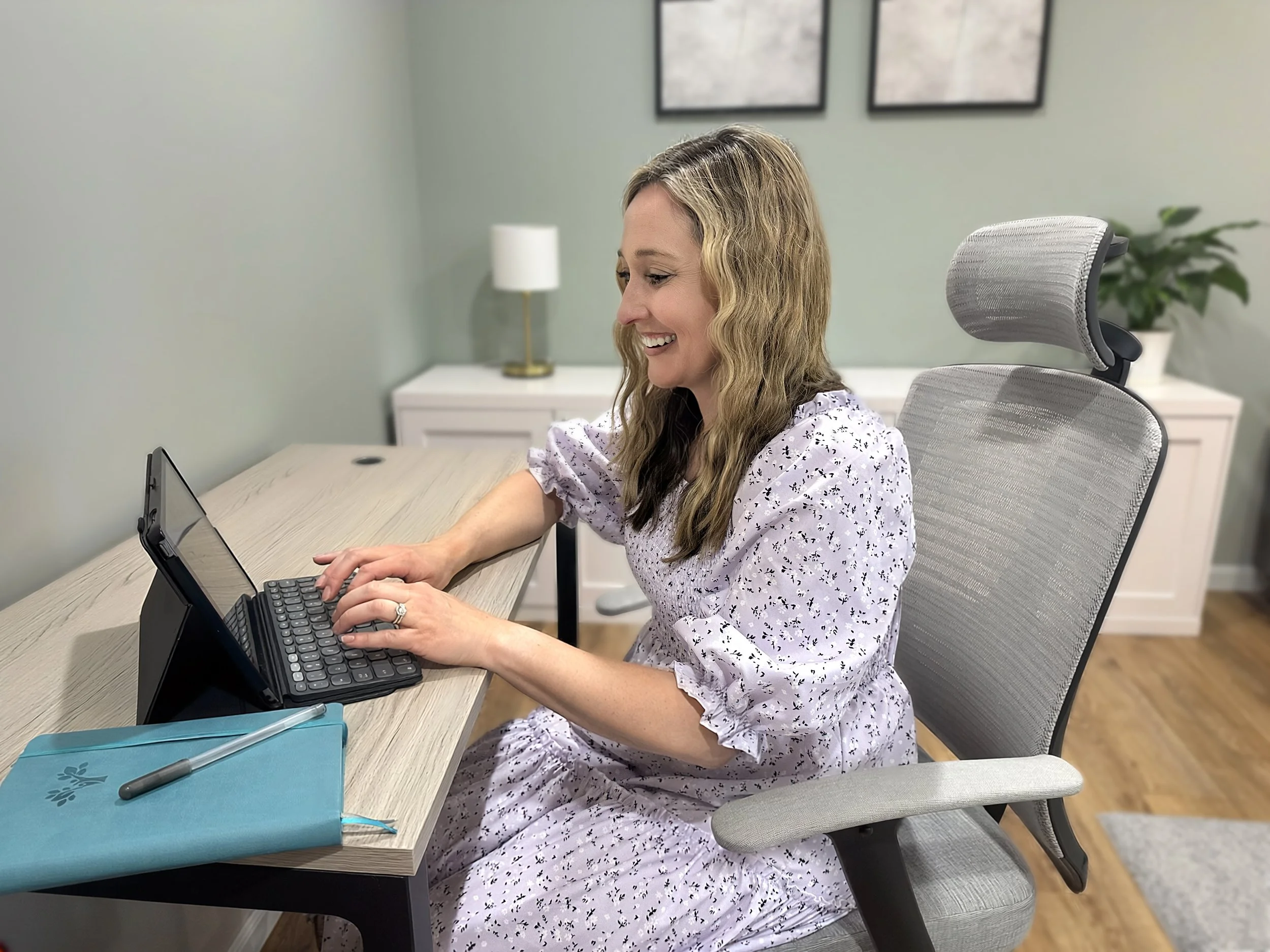 The owner, Gina, typing on her computer