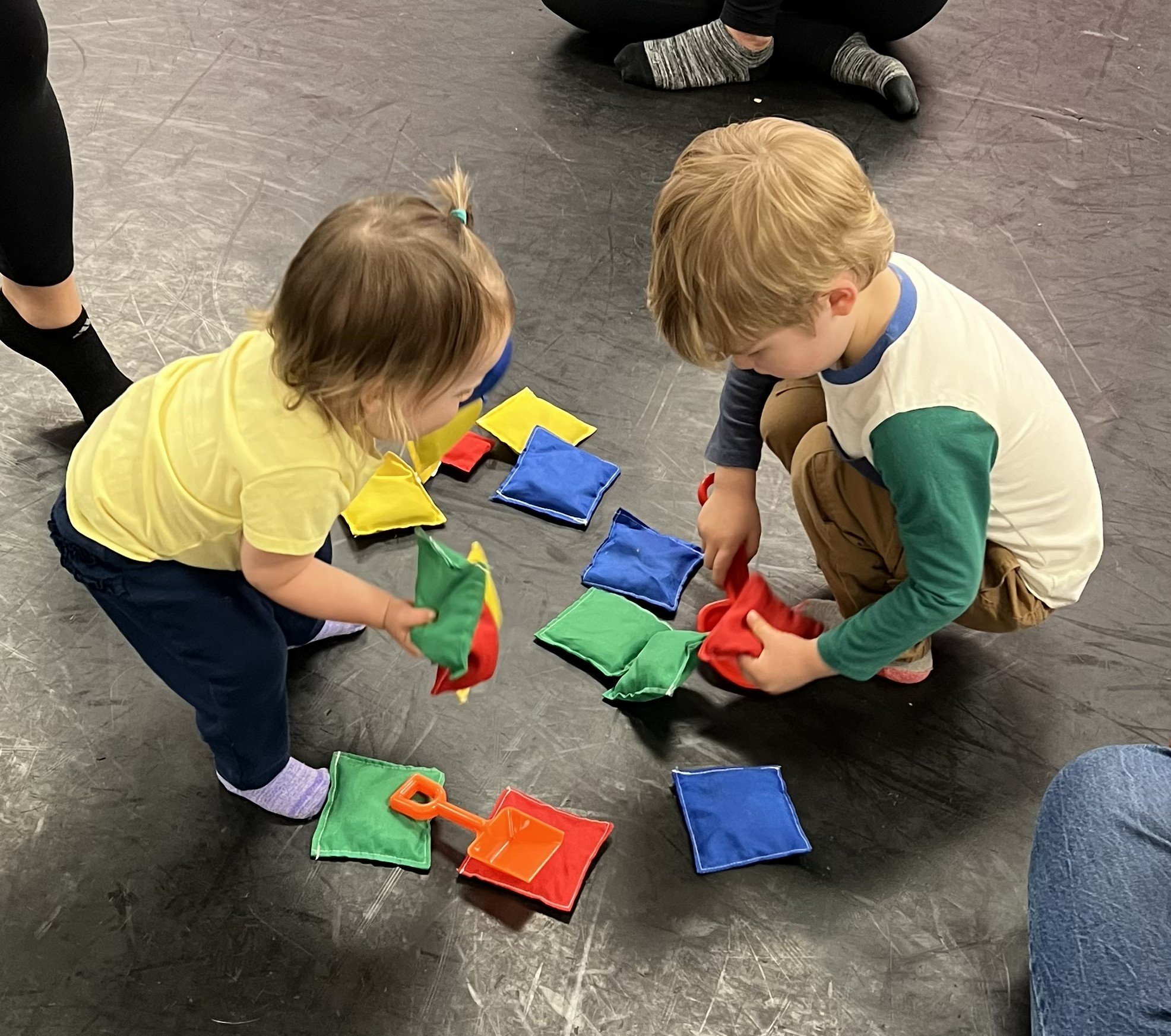 two toddlers playing with beanbags