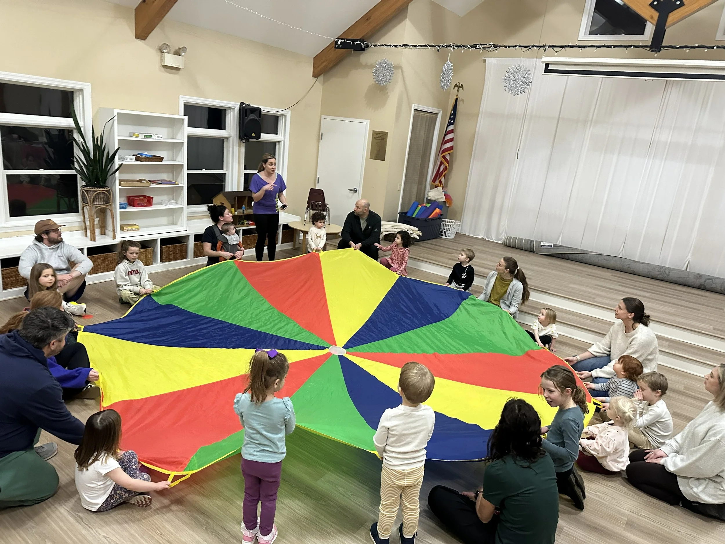 Families dancing with a giant parachute