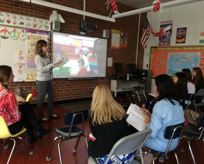 The owner, Gina, presenting a professional development workshop for a group of students