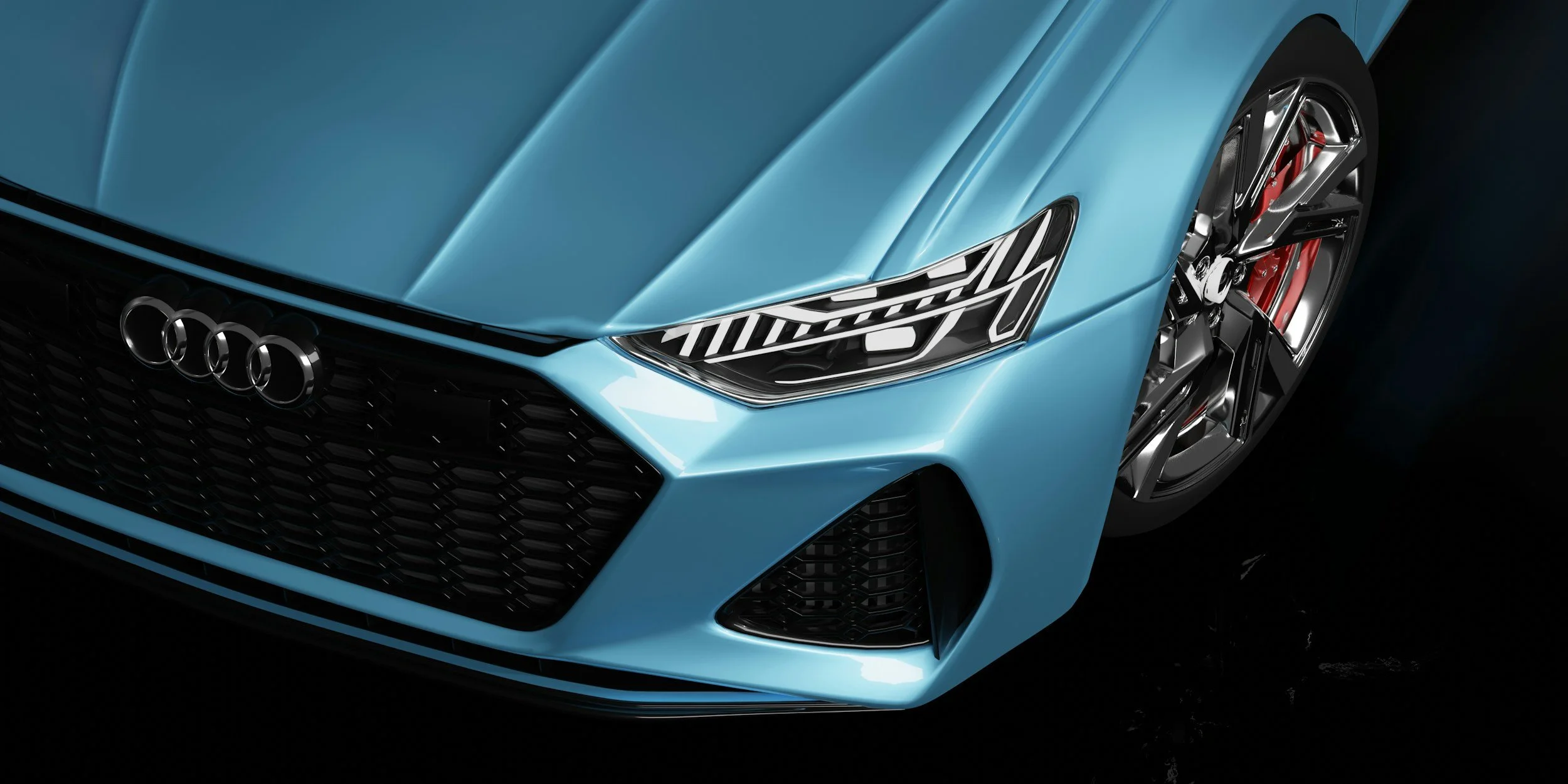 Close-up of the front of a blue Audi sports car, highlighting the headlight, grille, and one wheel with a red brake caliper.