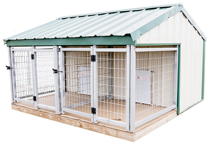 A fenced outdoor animal coop with a sloped metal roof, wooden base, and wire mesh sides, containing two white objects inside.