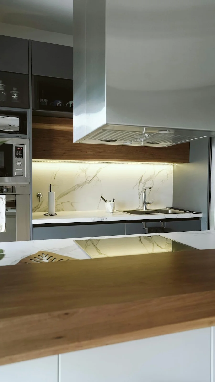 Cocina moderna con encimera de mármol, fregadero y utensilios de cocina.