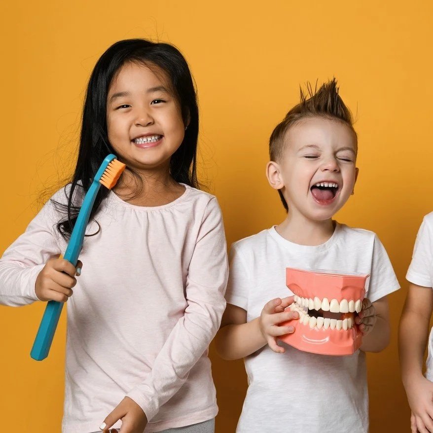 Two children, a girl and a boy, enjoying a positive dental visit at Accent Your Dentist, helping build healthy smiles for life.