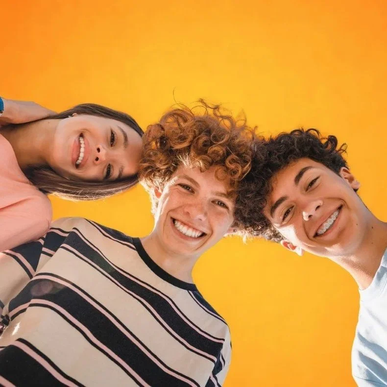 Three teenagers smiling together after personalised dental care at Accent Your Dentist in Ponsonby, Auckland.