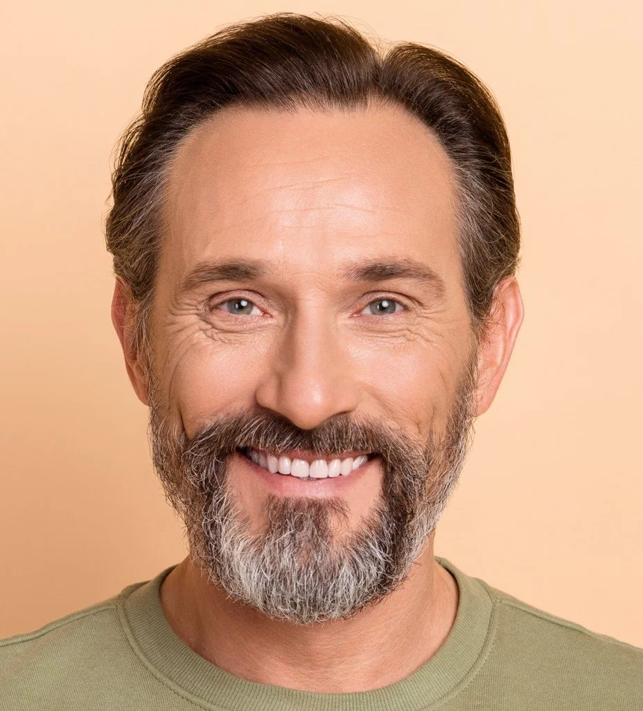 Close-up portrait of a smiling middle-aged man with a beard, mustache, and gray hair