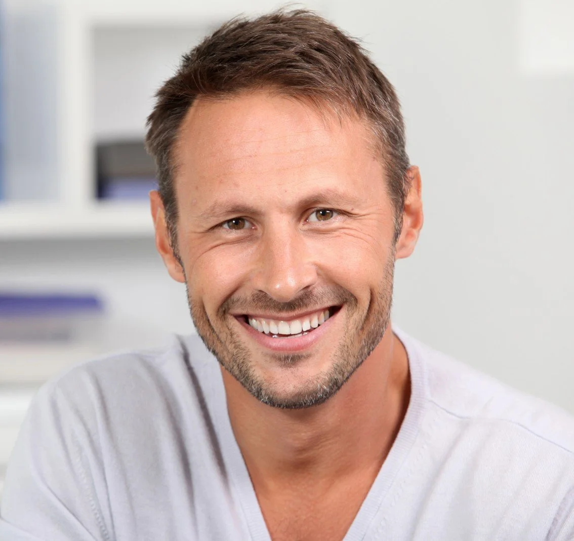 Smiling middle-aged man after restoring his smile with a custom dental crown at Accent Your Dentist in Ponsonby, Auckland.
