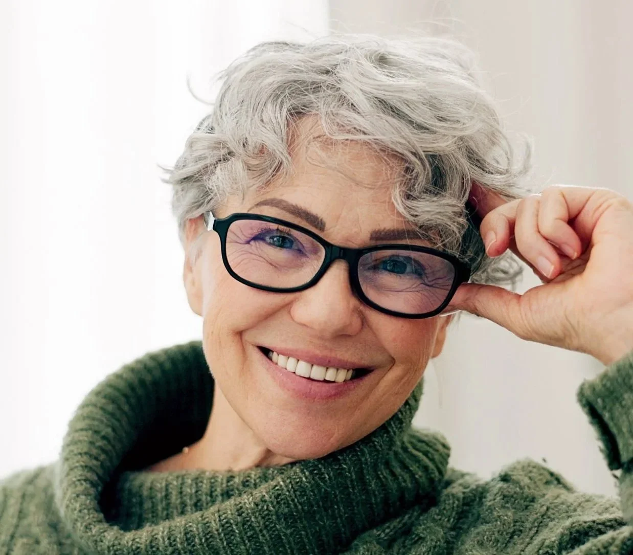 Older woman with glasses smiling after a full mouth restoration at Accent Your Dentist in Ponsonby, Auckland, restoring her smile and oral function.