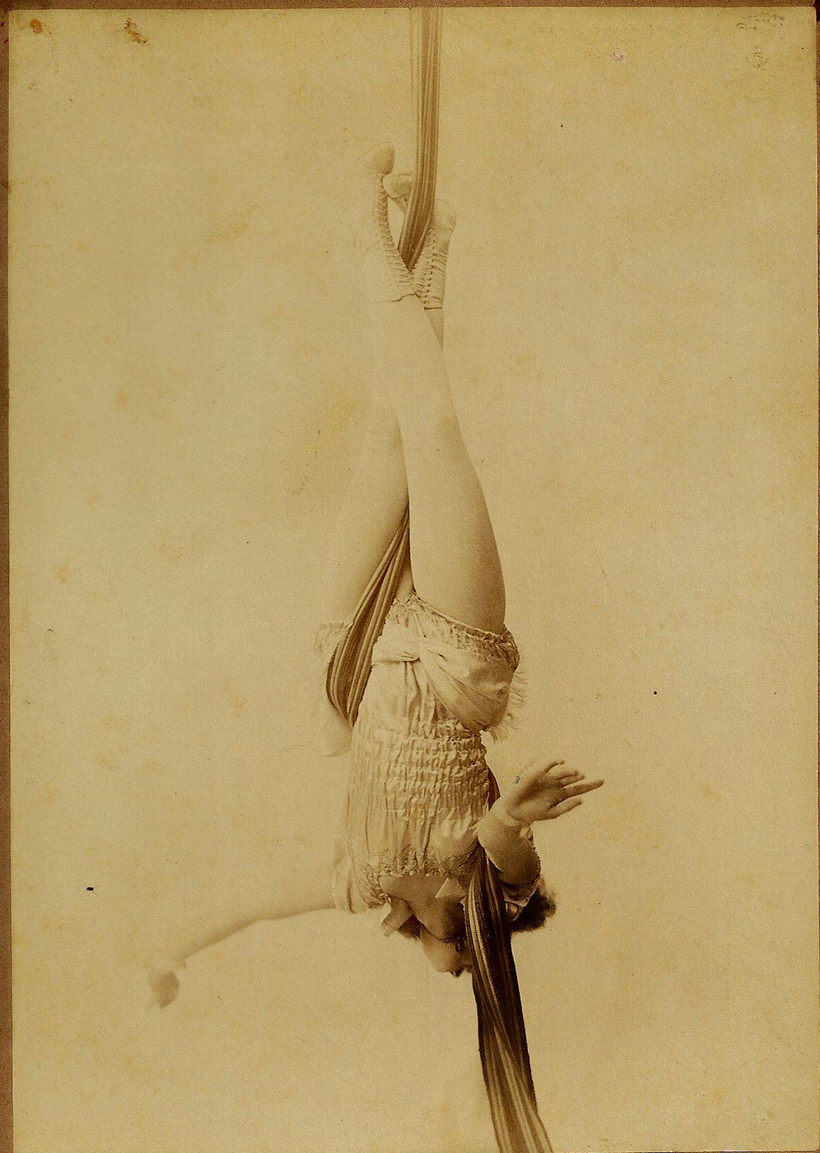 An image of a circus performer on silks from the 1900s