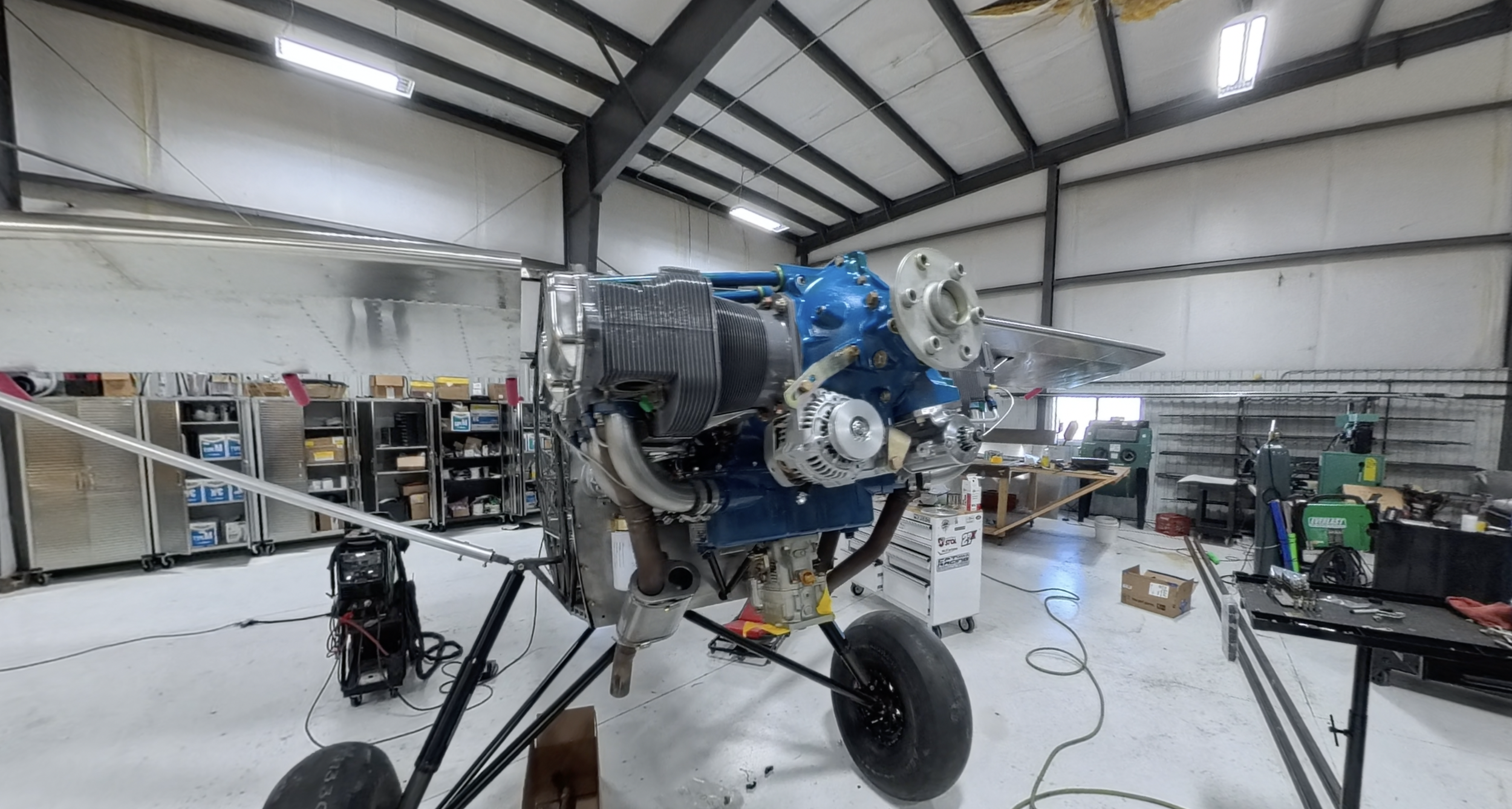 A partially assembled aircraft engine mounted on a stand inside a workshop.