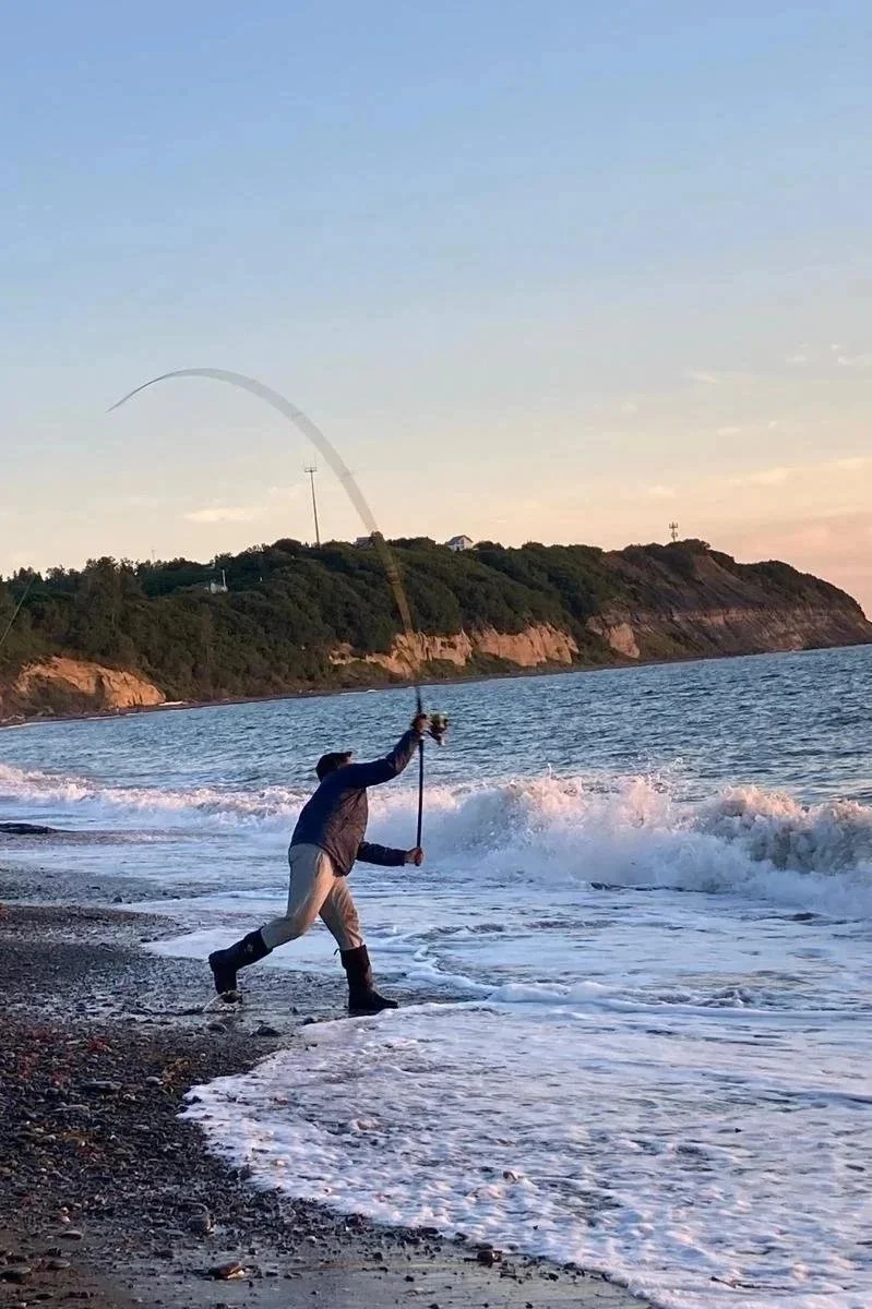 A surf fishing guide distance casting in Ninilchik, Alaska.