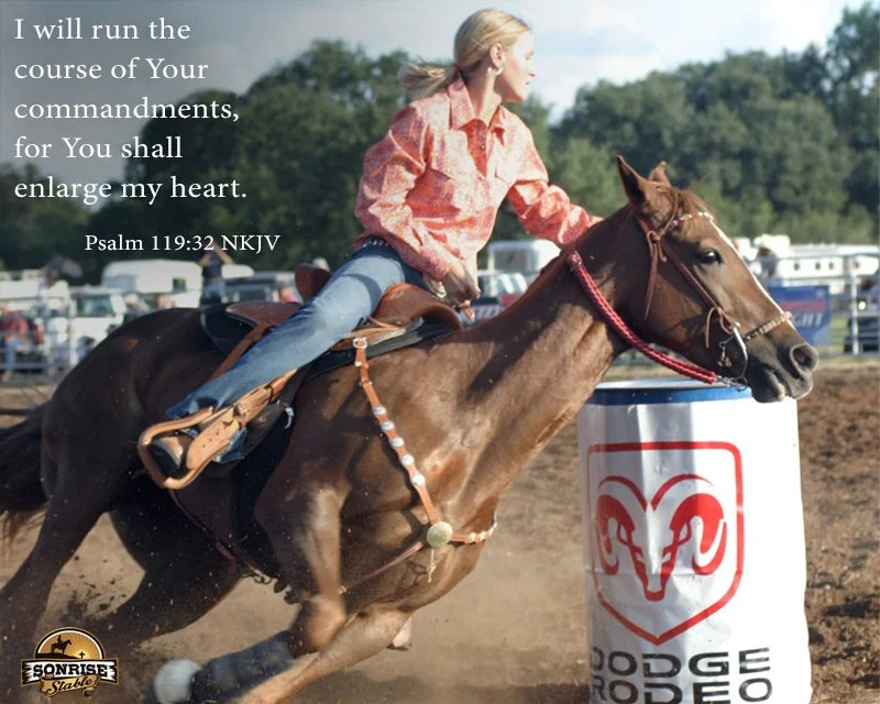A woman riding a horse at a rodeo or horse-riding event, with a Scripture quote overlaid on the image. The quote from Psalm 119:32 NKJV reads, "I will run the course of Your commandments, for You shall enlarge my heart."