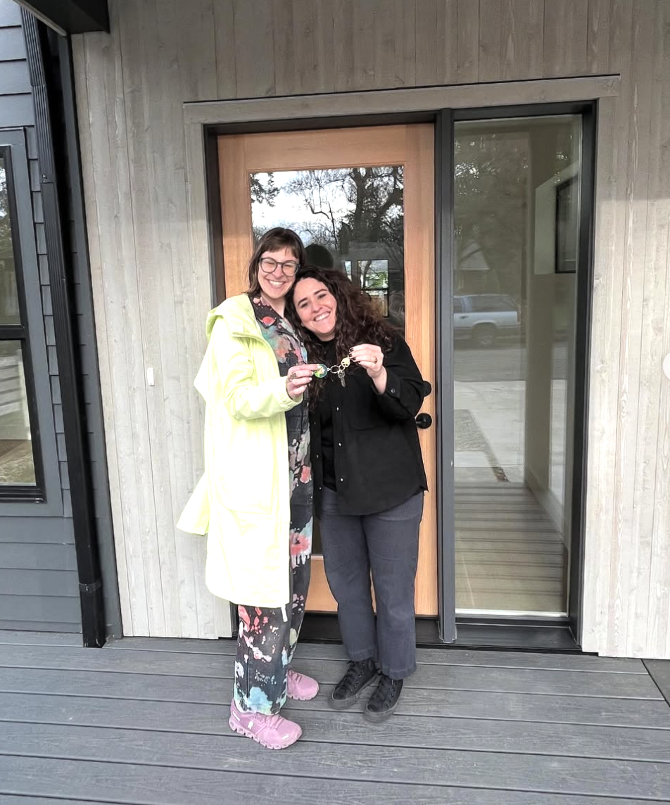 Two clients of Lou Chain, holding up a key, smiling.