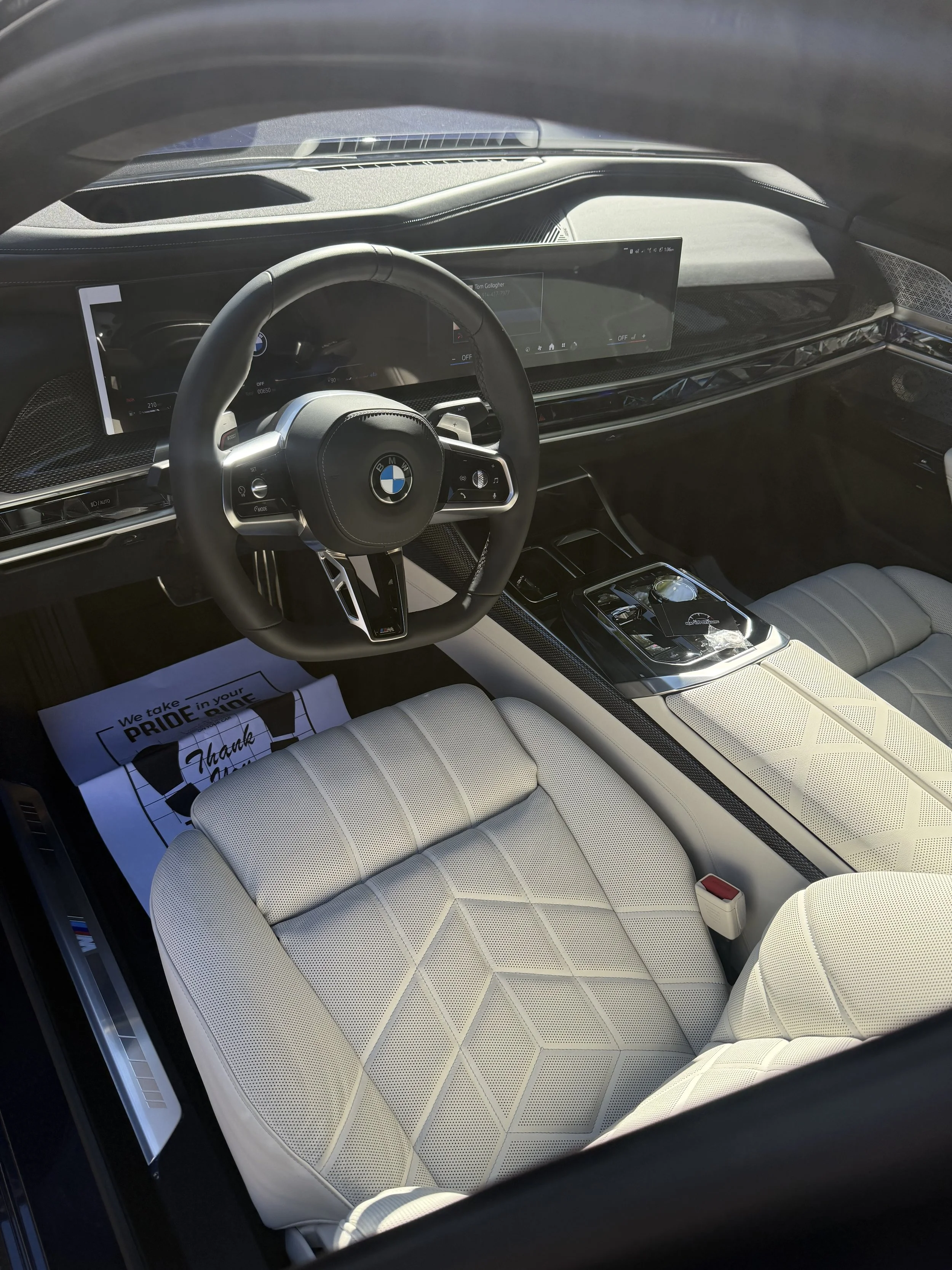 Interior of a BMW car with beige seats, digital dashboard, and center console.