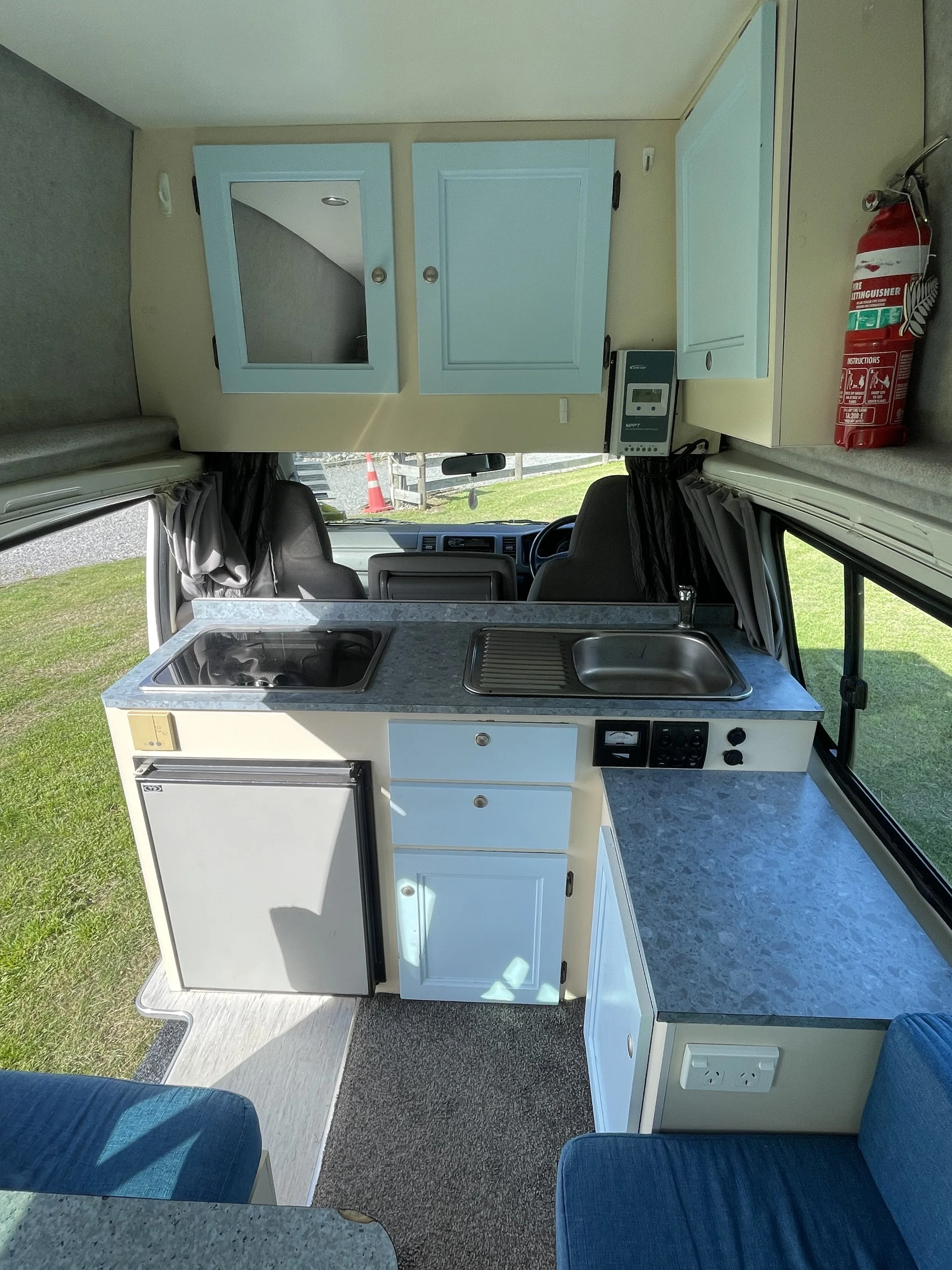 Kitchen countertop with a sink, a potted plant, a stove, and a refrigerator in a small kitchen