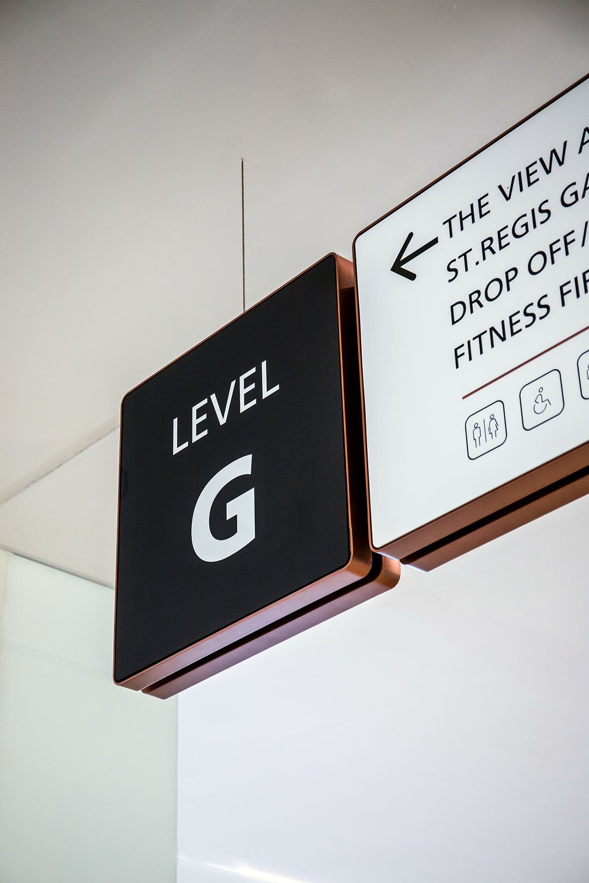 Retail Wayfinding Dubai. Sign indicating Level G and directional signs with additional information in an indoor setting.
