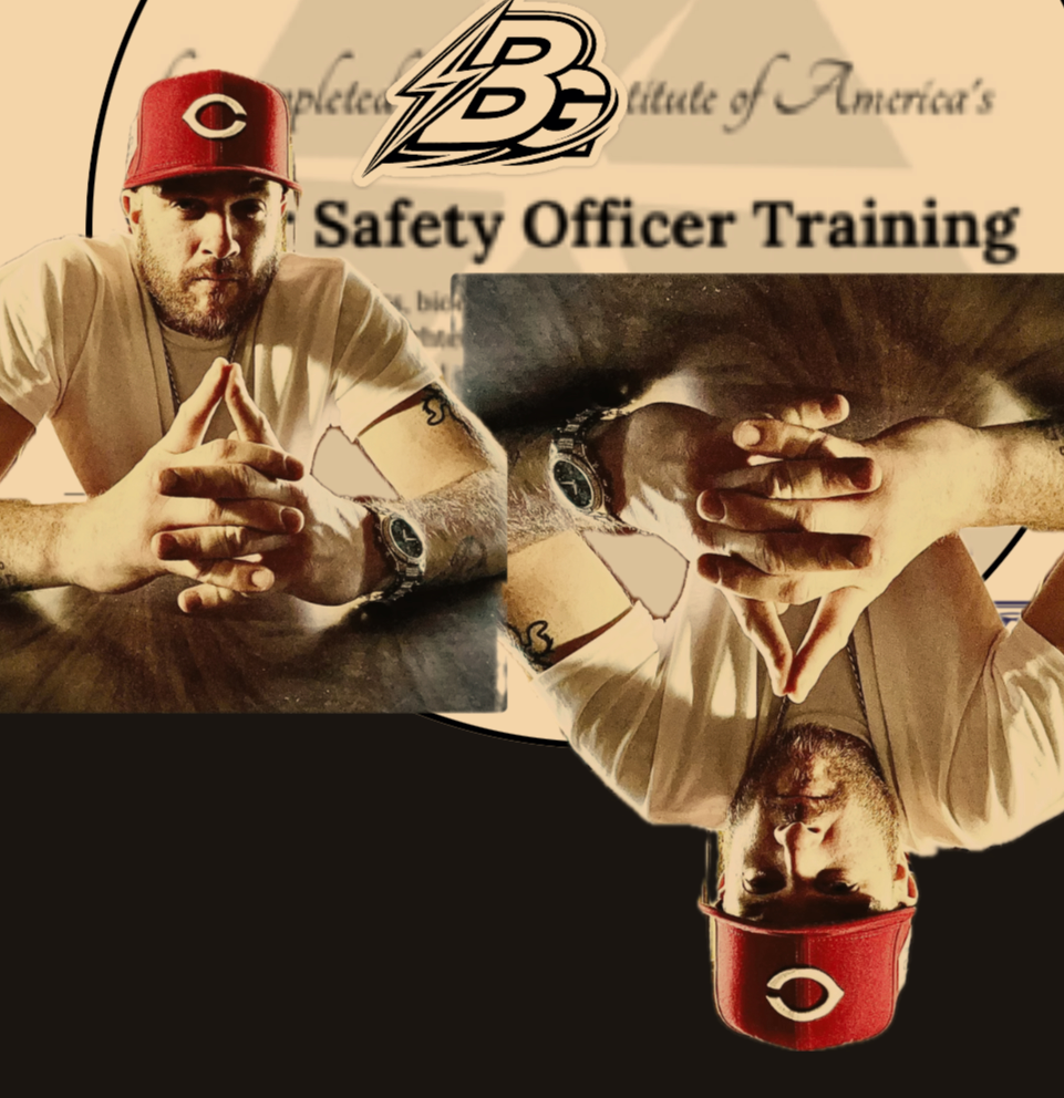 A man with a red Cincinnati Reds cap and beige shirt, sitting at a table with his hands together in a prayer-like gesture, is reflected upside down. The background shows a poster with the text 'Safety Officer Training' and the logo of 'BG'.