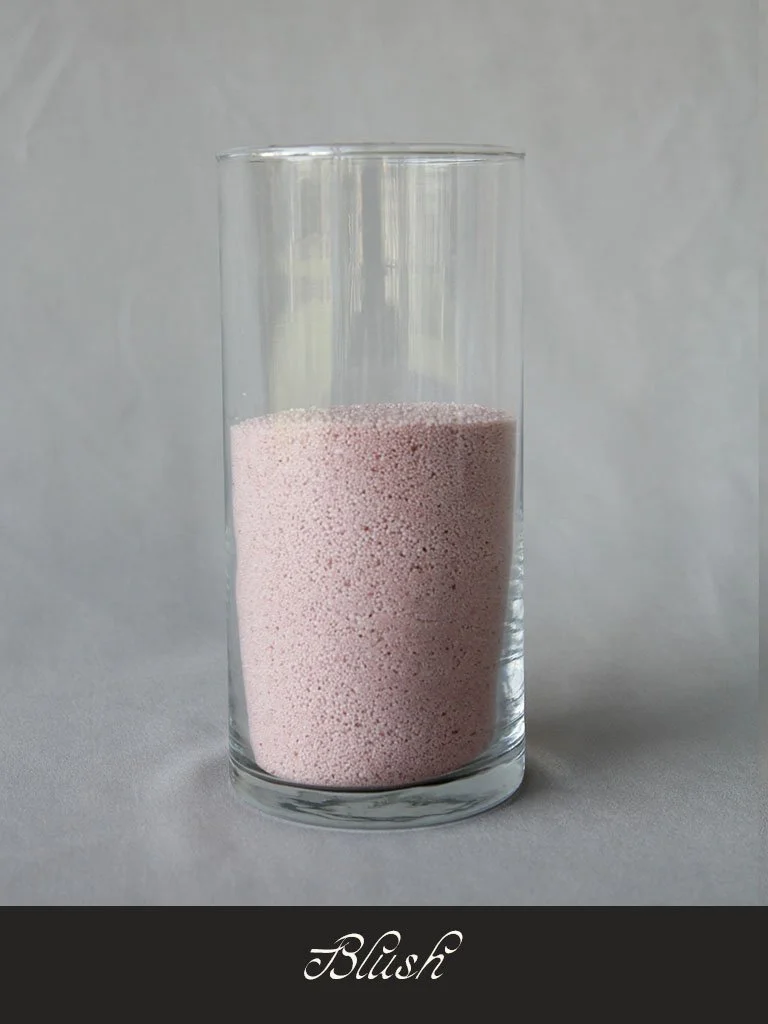 A clear glass filled with light pink, blushed powdered substance.