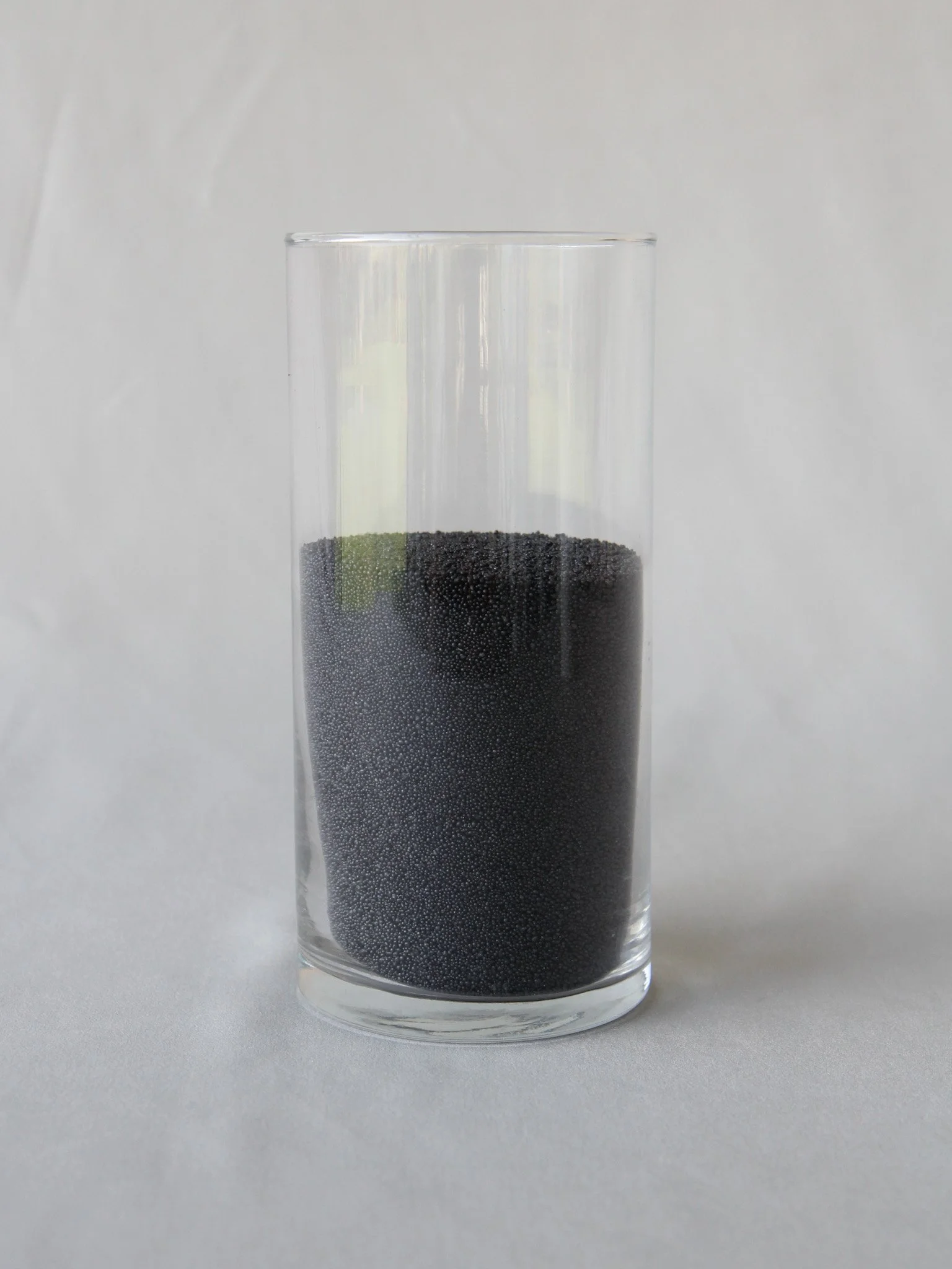 A tall glass filled with black caviar.