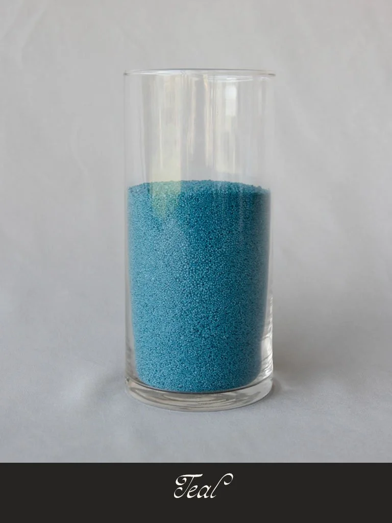 A tall clear glass filled with blue spherical sprinkles labeled "Tea" at the bottom.