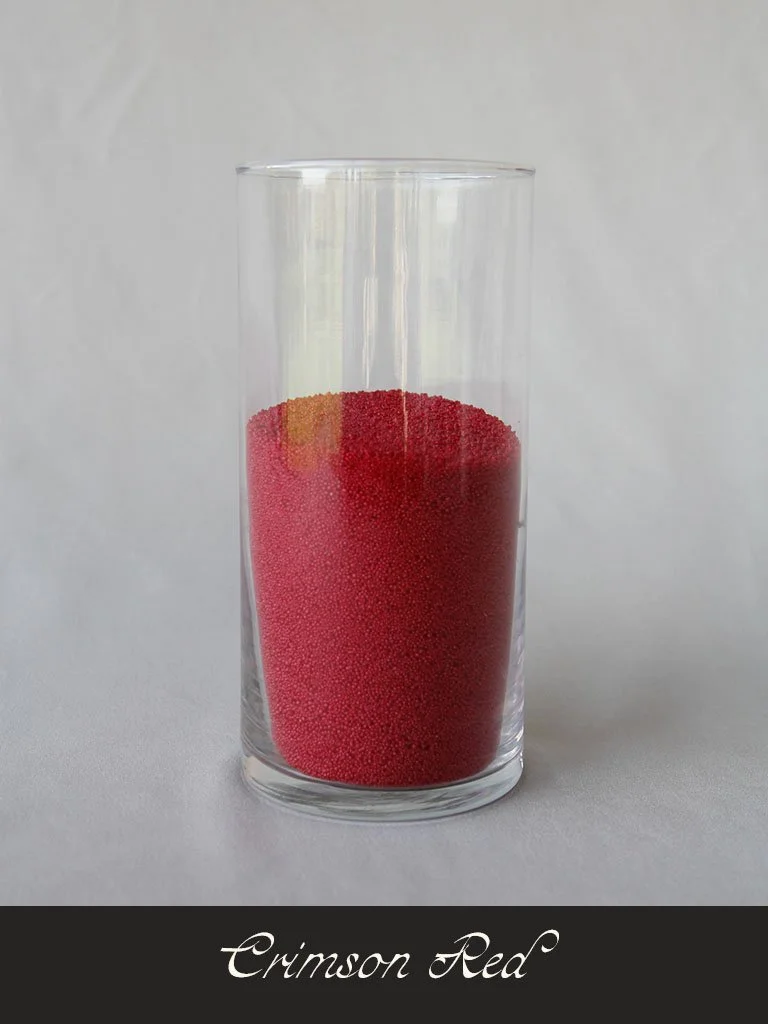 A clear glass tumbler filled with red powdered substance labeled 'Crimson Red' at the bottom.
