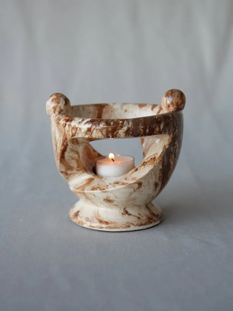 Marble-colored candle holder with a tea light candle inside
