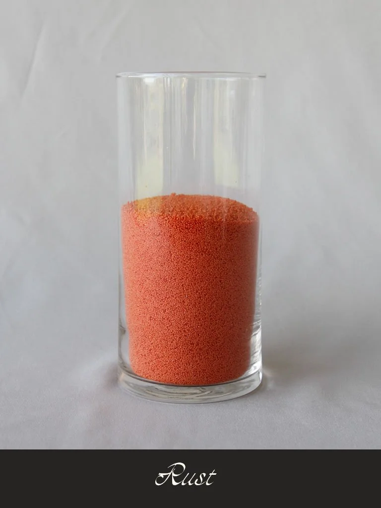 A tall clear glass filled with reddish-orange tiny beads labeled 'Rust' at the bottom.