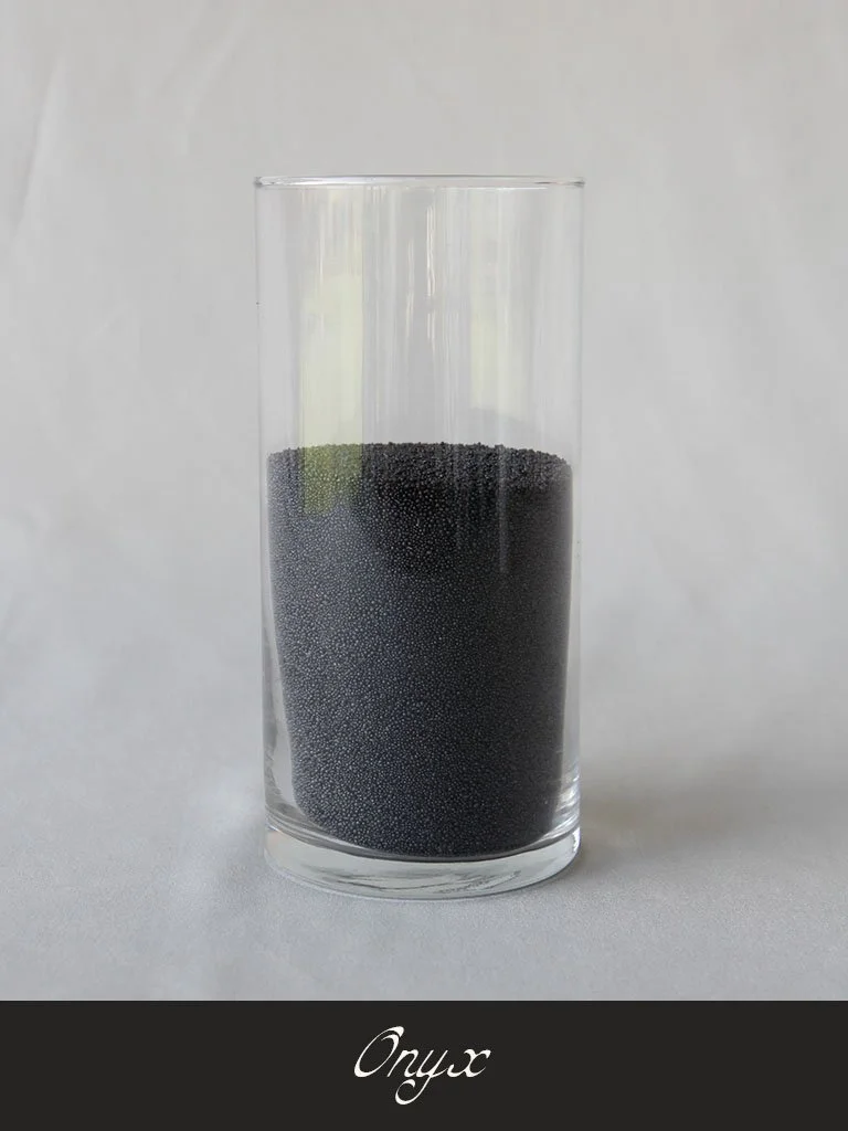 A tall clear glass filled with black caviar against a plain light background with the brand 'Onyx' written below.