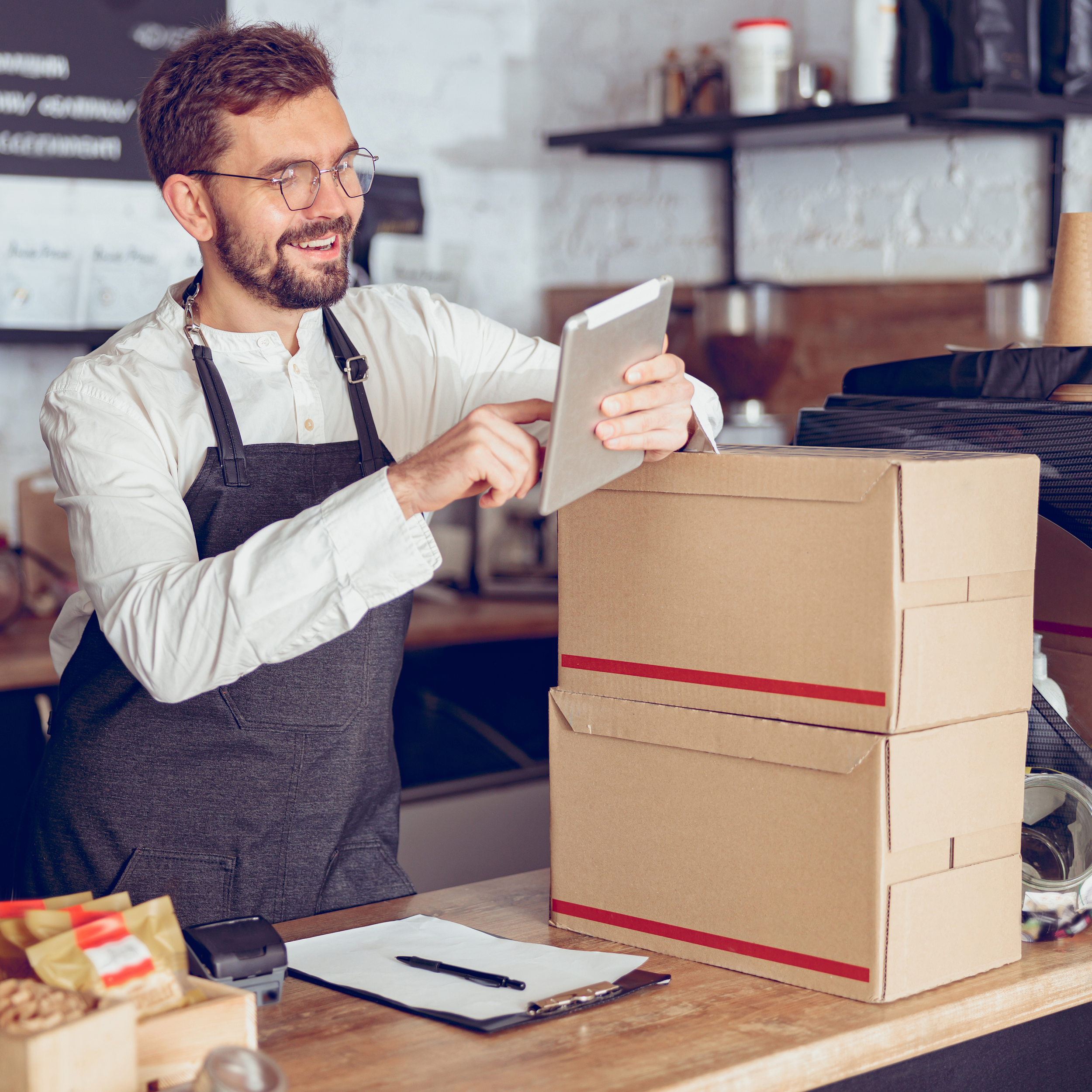 This is an image made to represent a restaurant owner. He holds a tablet in his hands, and is resting his left elbow on a few bocks.