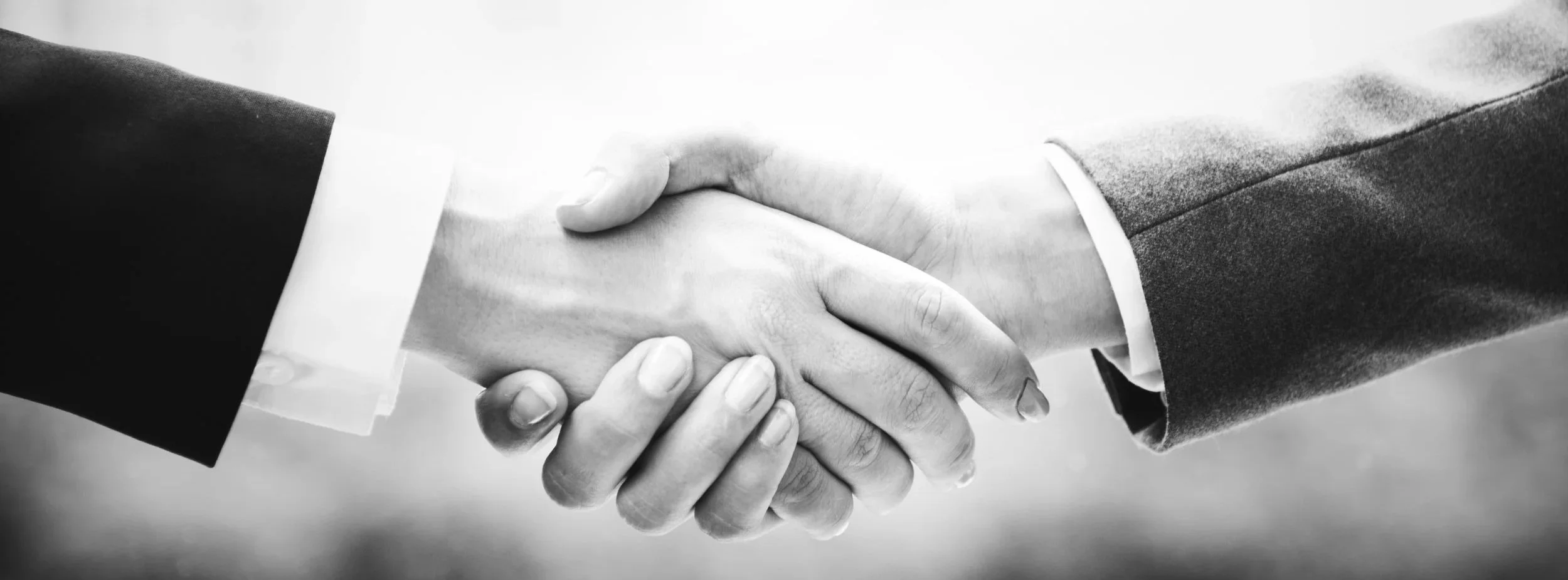 Close-up of two people shaking hands in a professional setting.