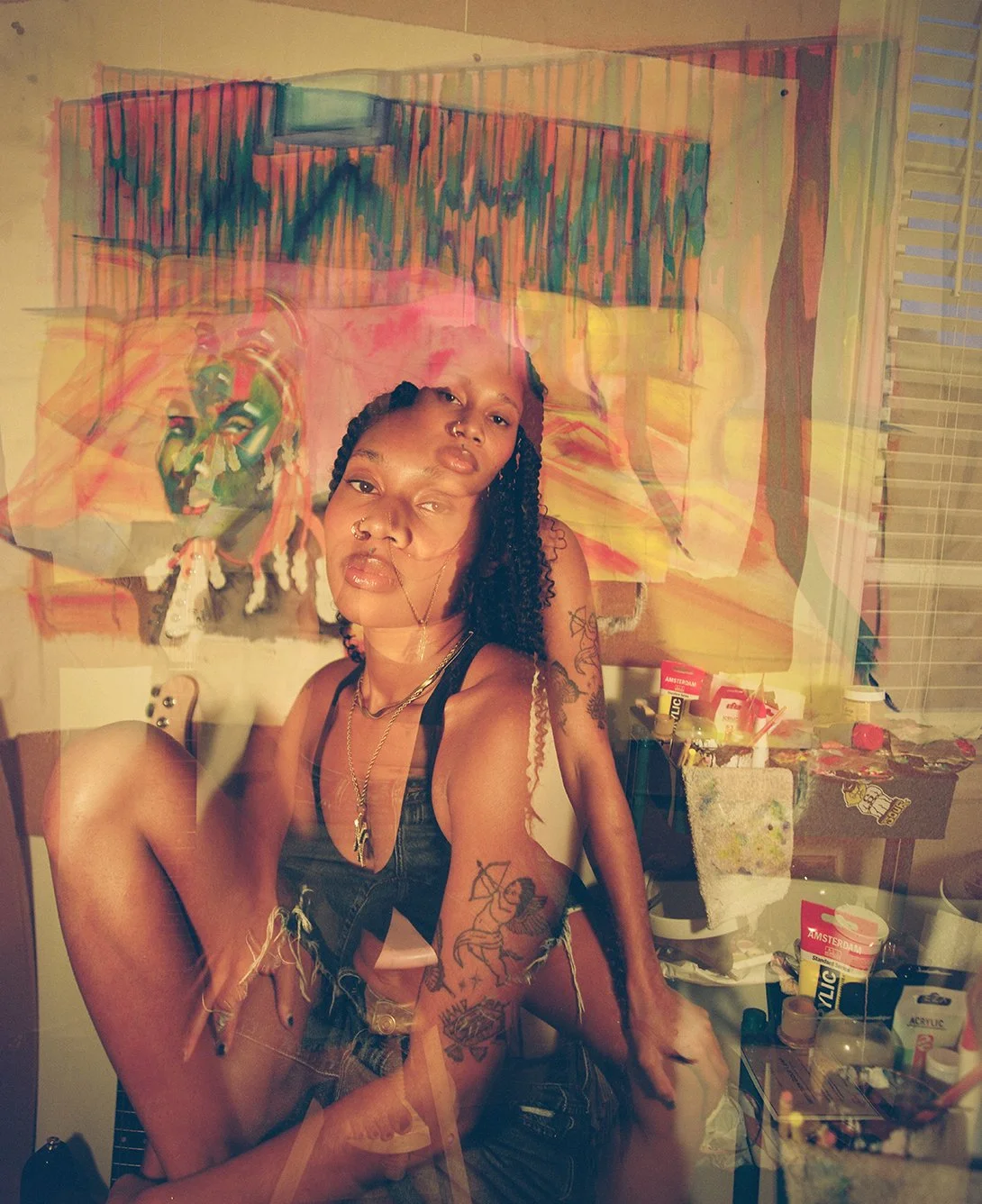 Double exposure of woman sitting in front of a canvas painting on her wall