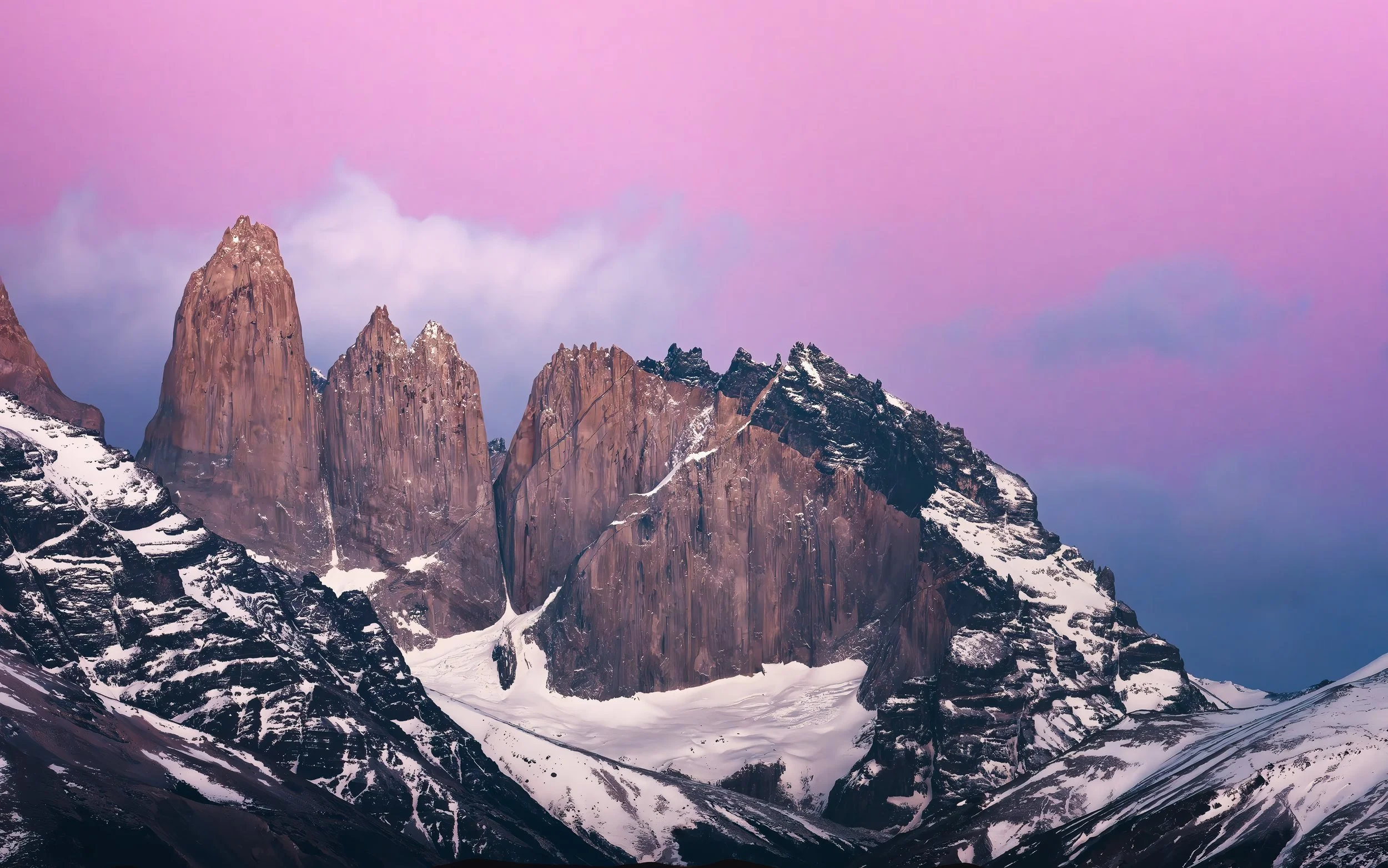 Torres del Paine, snow-covered mountain peaks under a pastel pink and purple sky during sunrise