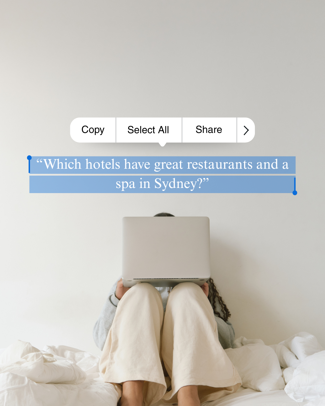 Person sitting on bed, holding a laptop in front of their face, with a text overlay asking about hotels with restaurants and spas in Sydney.
