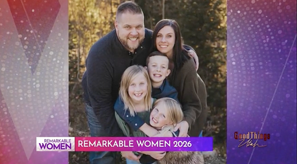 Family photo of a man, a woman, and three children outdoors during fall, smiling and hugging.