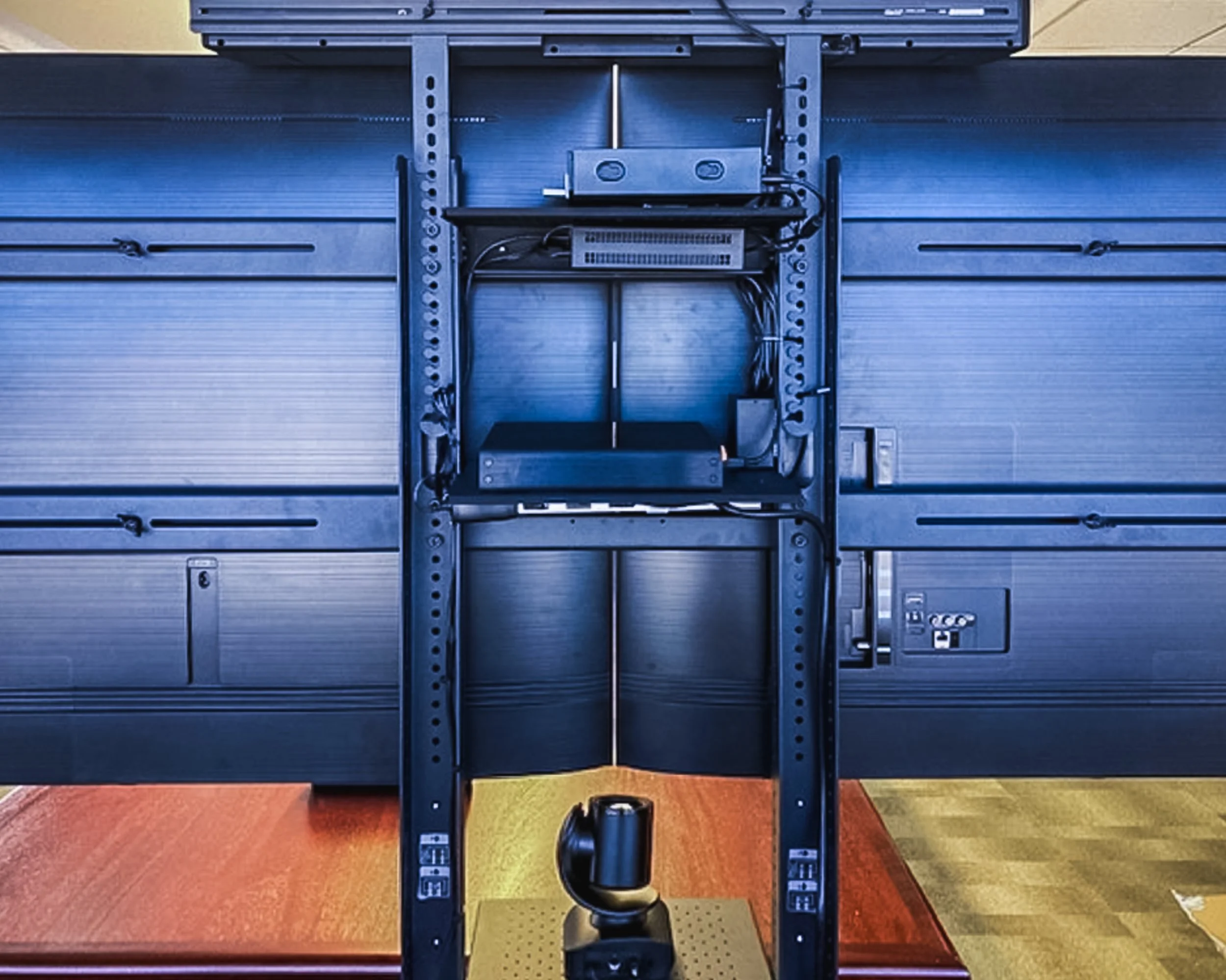 View of the back of a treadmill, showing mechanical and electrical components with the treadmill belt and motor visible.