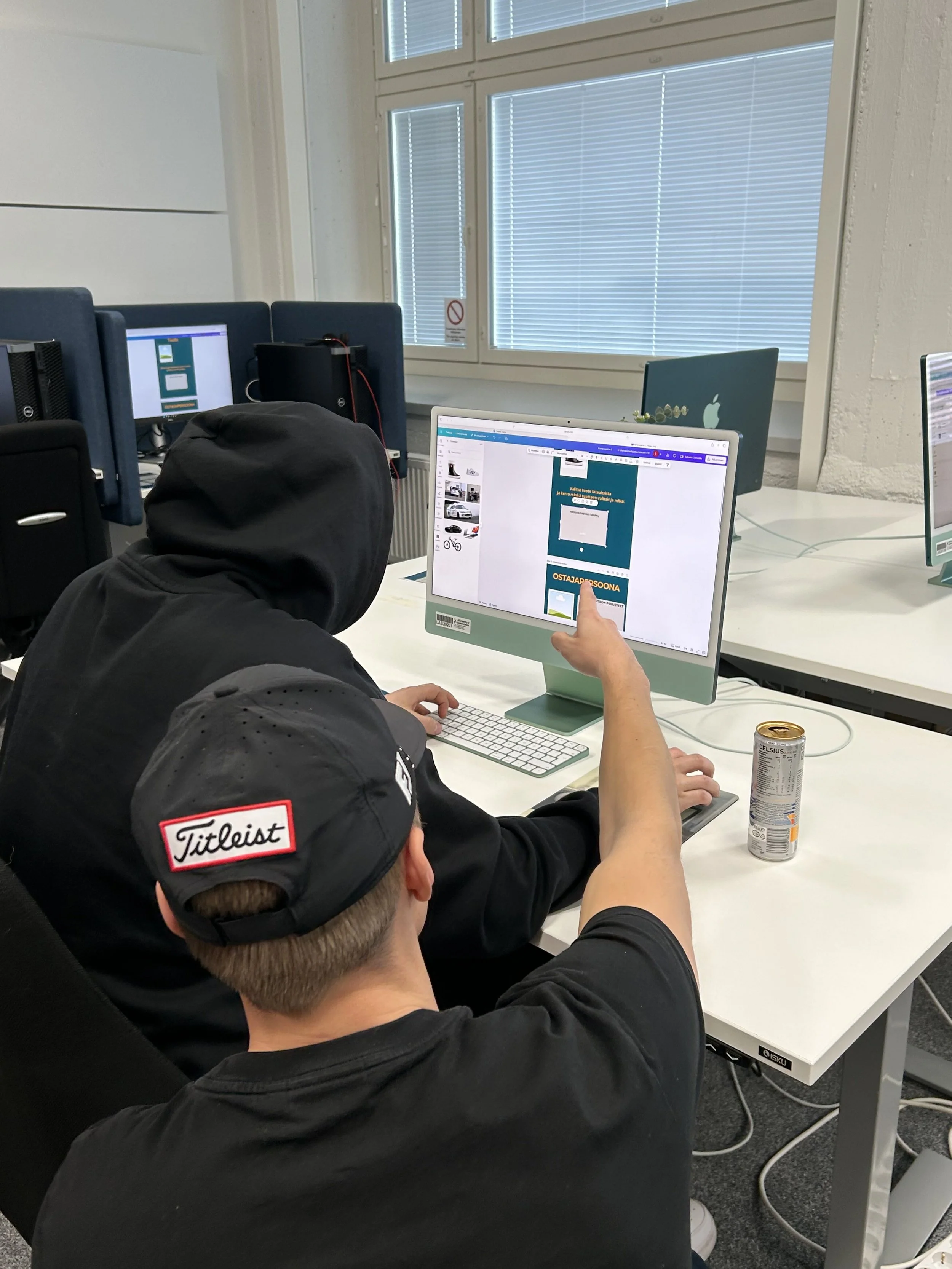 Kaksi henkilöä työskentelee tietokoneella toimistossa.