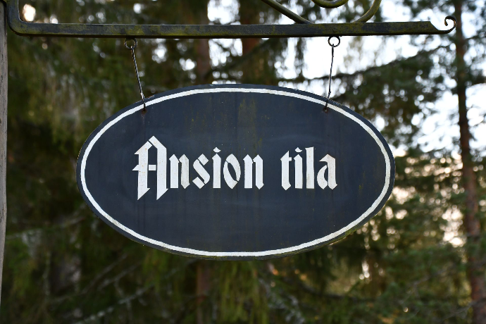 Tumma roikkuva kyltti, jossa lukee 'Ansion tila'.